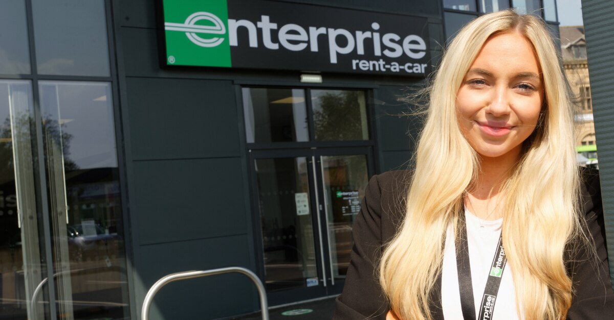 Selfie of female worker in front of Enterprise sign