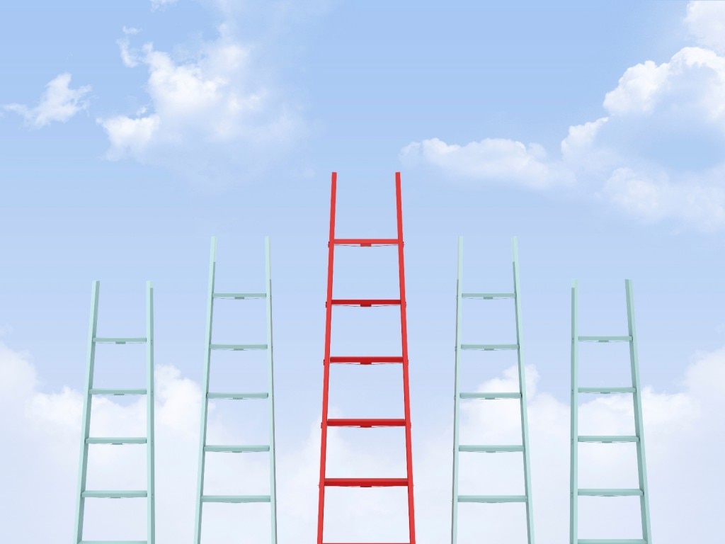 Cinco escaleras con una roja más alta en el medio sobre un fondo del cielo