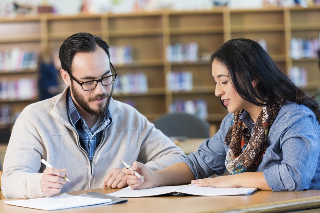 Estudiantes revisando notas en una biblioteca