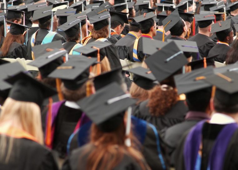 Estudiante con gorras y batas de graduación