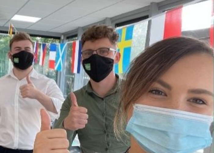 Los empleados de Enterprise llevan máscaras en la oficina para una selfie