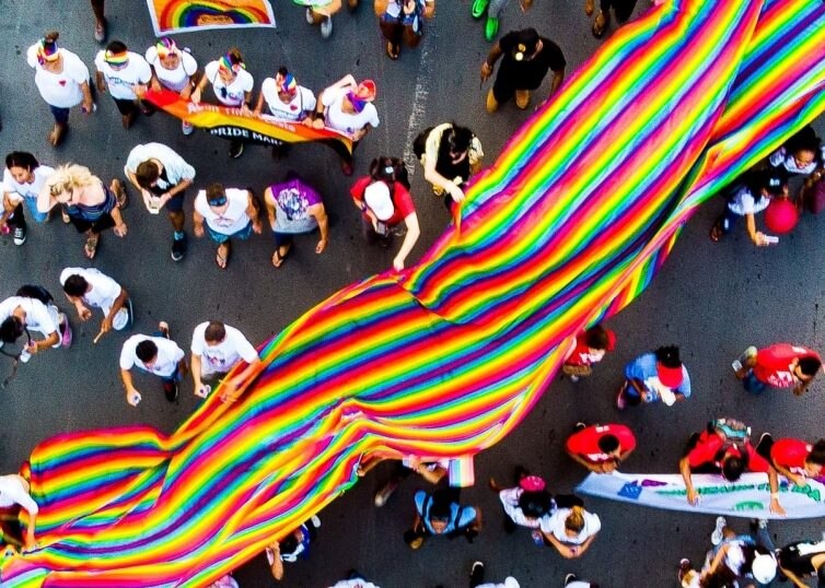 Desfile DEL ORGULLO con una gran bandera DEL ORGULLO