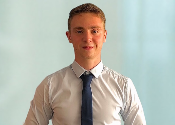 Foto de Fabio con camisa blanca y corbata negra sobre fondo azul claro