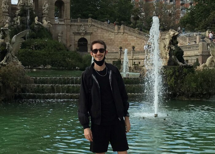 Nicolás de pie frente a una fuente