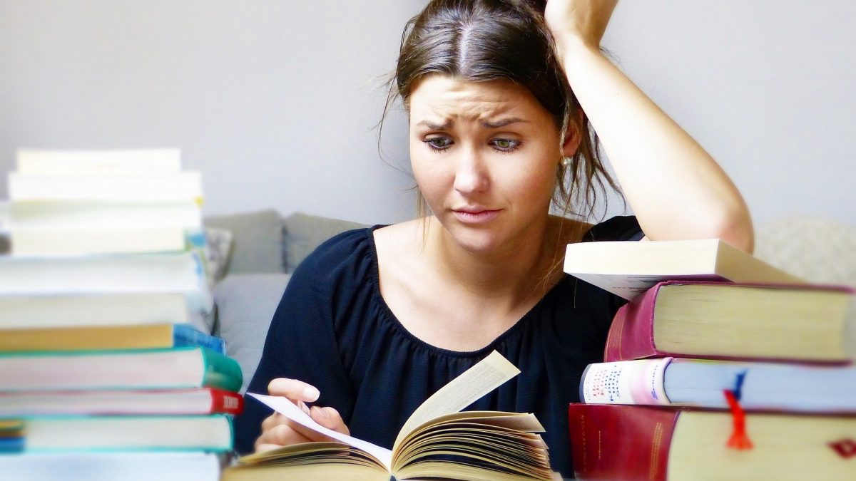 Chica estresada rodeada de libros