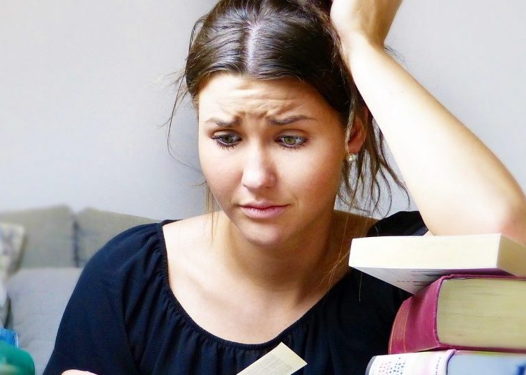 Chica estresada rodeada de libros