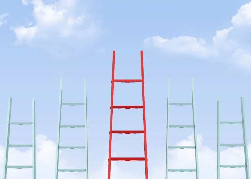 Cinco escaleras con una roja más alta en el medio sobre un fondo del cielo