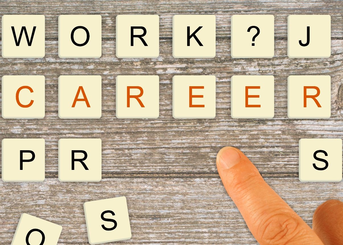 Las fichas de letras están ordenadas por un dedo para deletrear "trabajo", "trabajo", "carrera" y luego las fichas adicionales dispersas