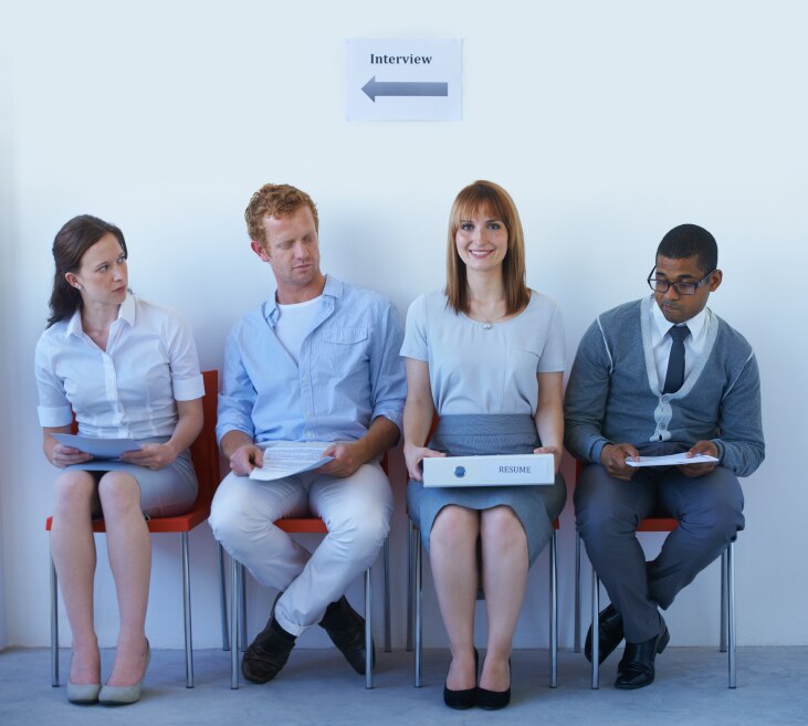 Cuatro personas esperando en sillas para una entrevista