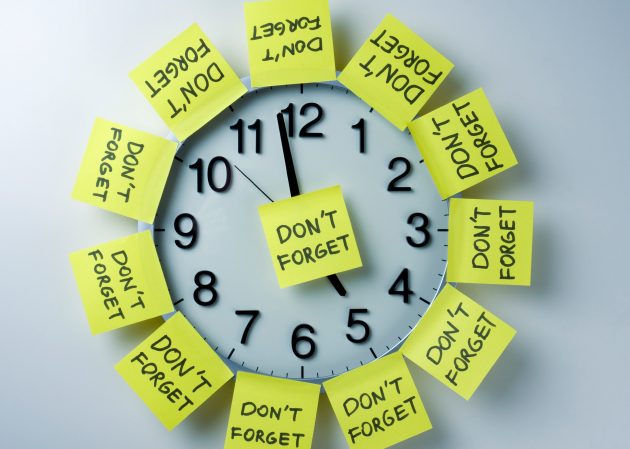 Reloj cubierto con notas adhesivas amarillas que dicen "no olvides"