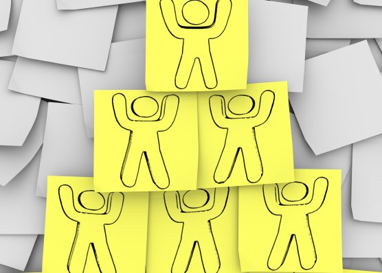 Notas adhesivas amarillas con personas dibujadas en ellas dispuestas en una pirámide
