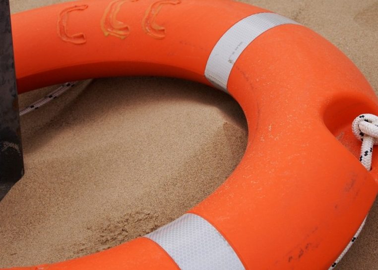 Salvavidas en naranja y blanco alrededor de un poste