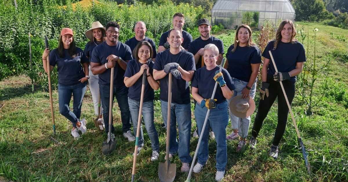 Personas con palas que se ofrecen como voluntarios en un jardín