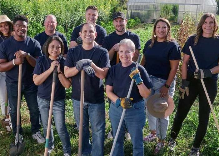 Personas con palas que se ofrecen como voluntarios en un jardín