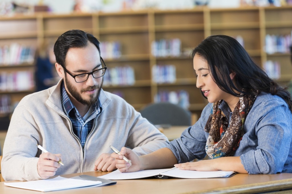 Estudiantes revisando notas en una biblioteca