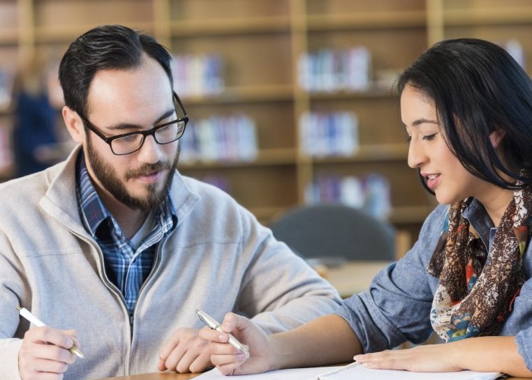 Estudiantes revisando notas en una biblioteca