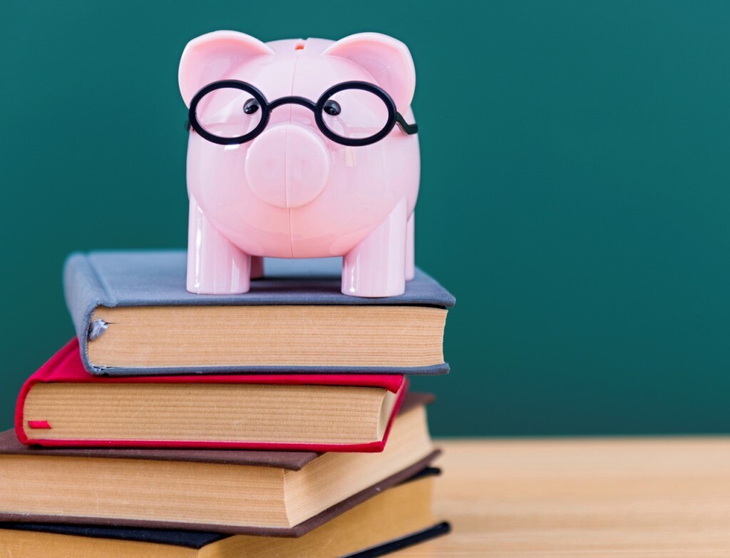 Banco de perros con gafas encima de un montón de libros