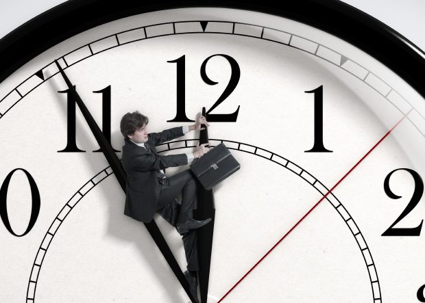 Un hombre con un maletín montado a la hora de un reloj