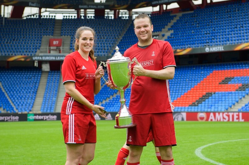Dos jugadores en uniforme con un trofeo