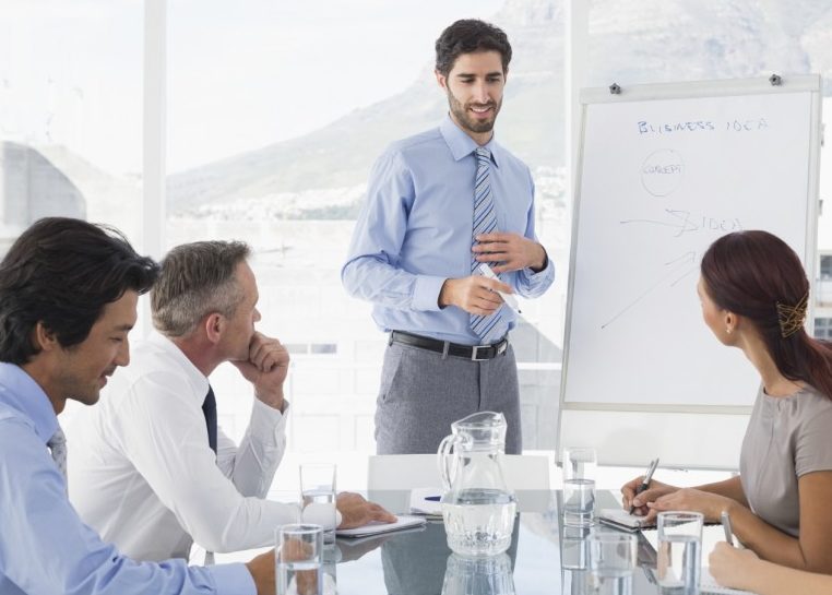 Reunión de negocios con el líder escribiendo en pizarra blanca