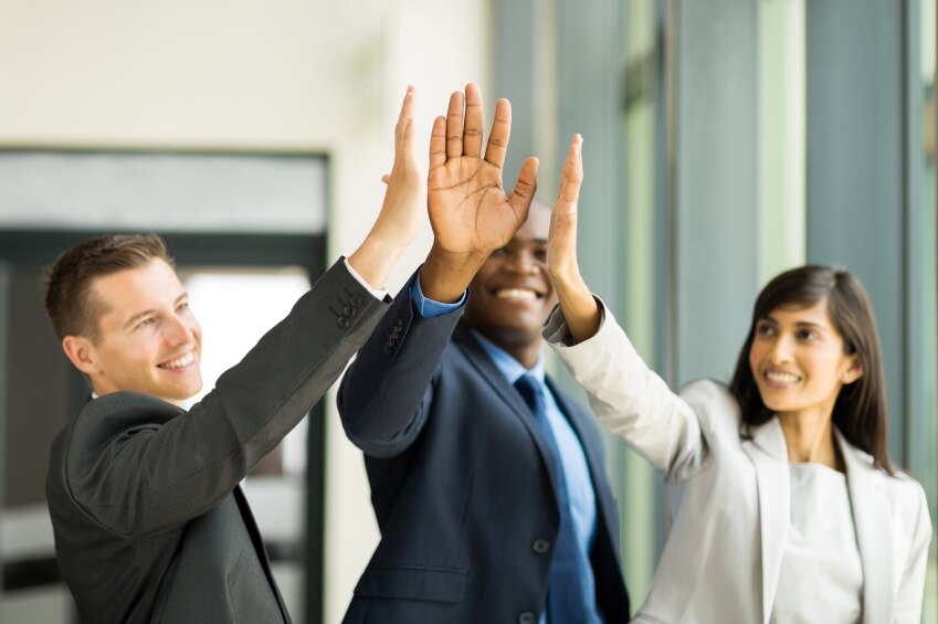 Tres compañeros de trabajo se dan entre sí un alto número de cinco