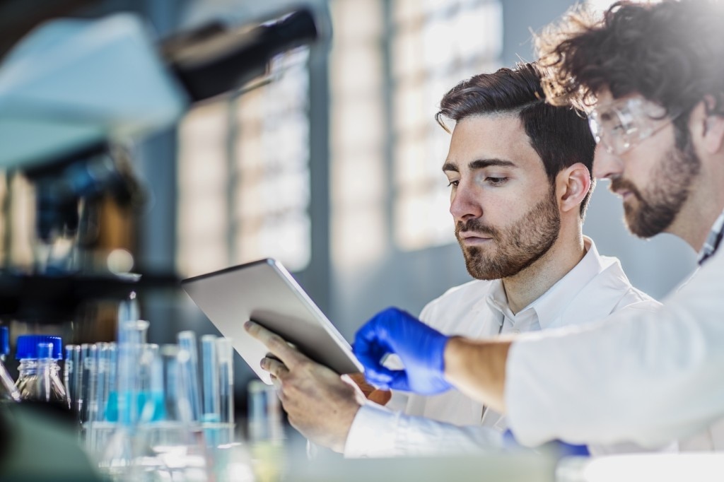 Dos científicos con batas de laboratorio en un laboratorio 
