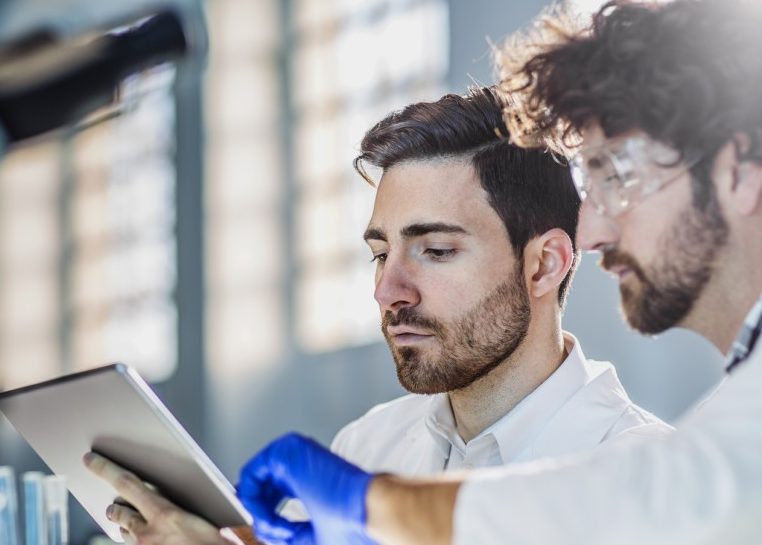 Dos científicos con batas de laboratorio en un laboratorio 