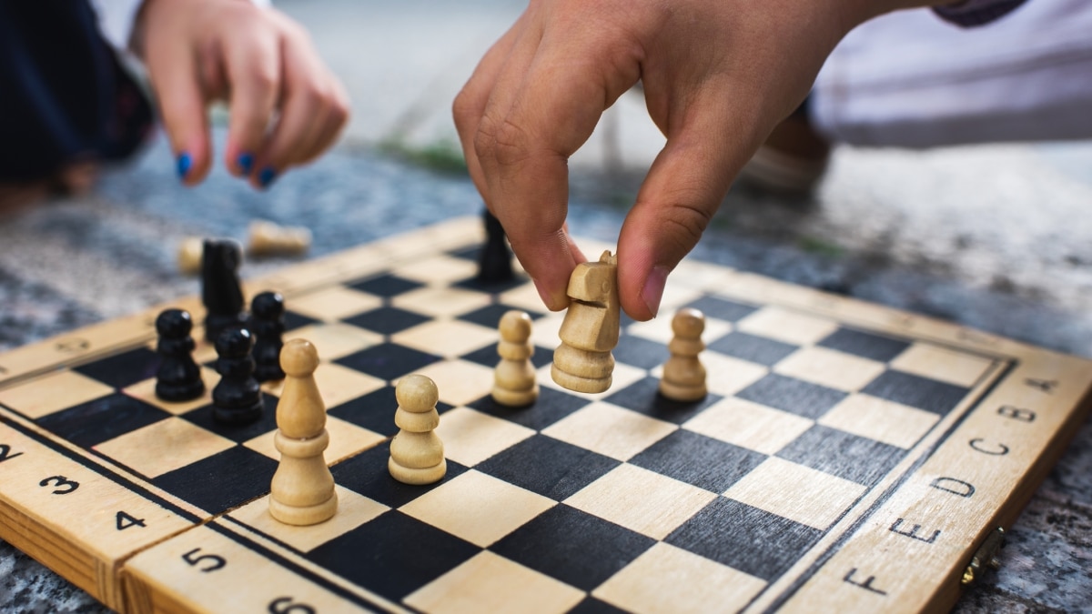 Tablero de ajedrez con dos manos jugando