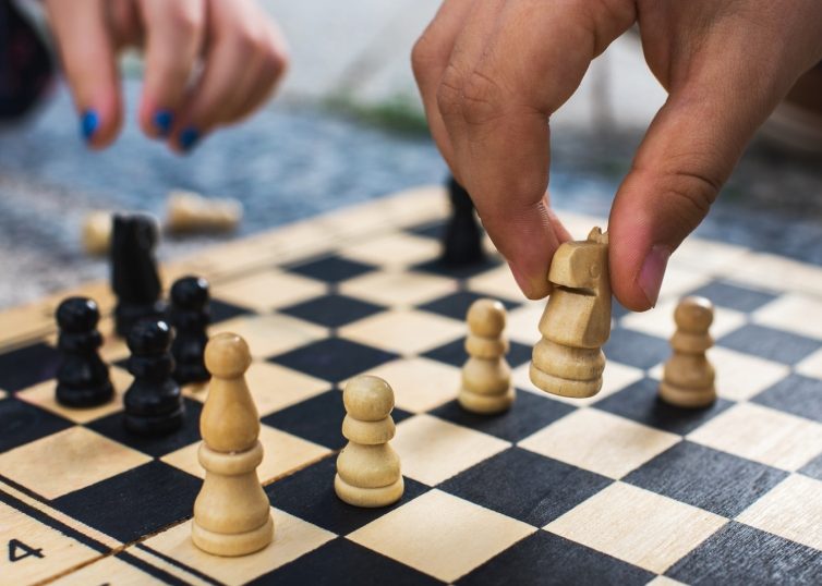 Tablero de ajedrez con dos manos jugando