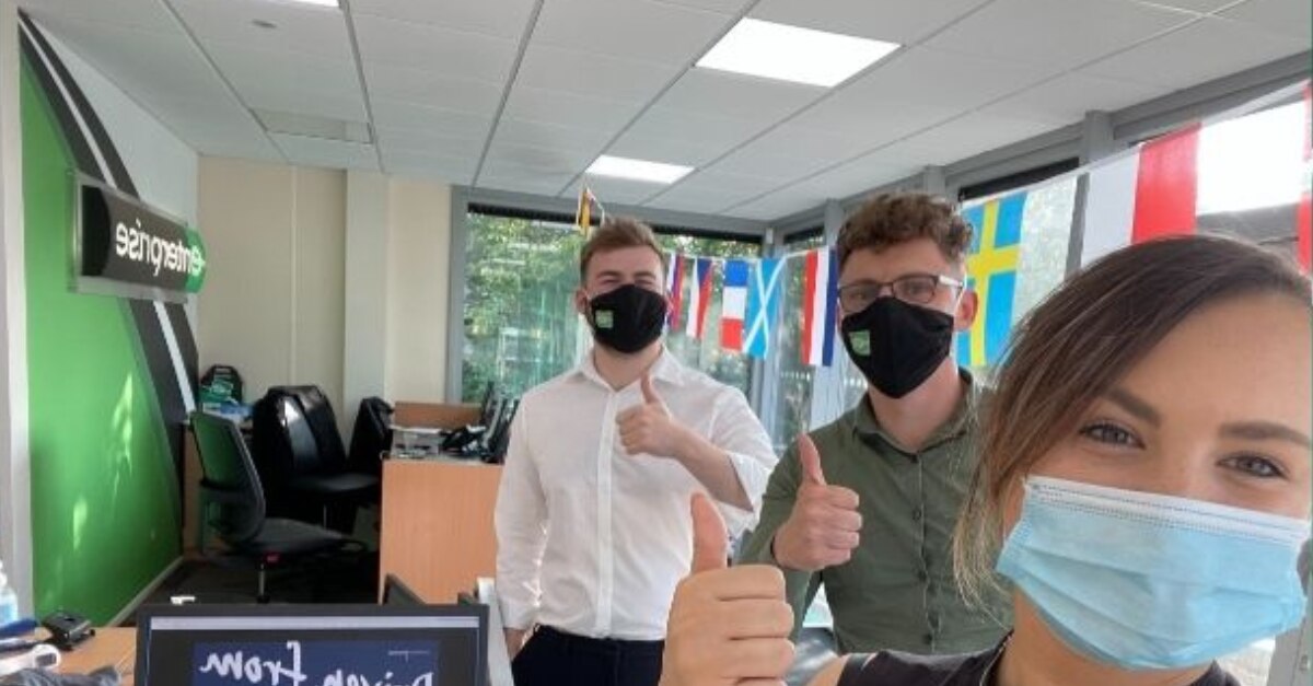 Los empleados de Enterprise llevan máscaras en la oficina para una selfie