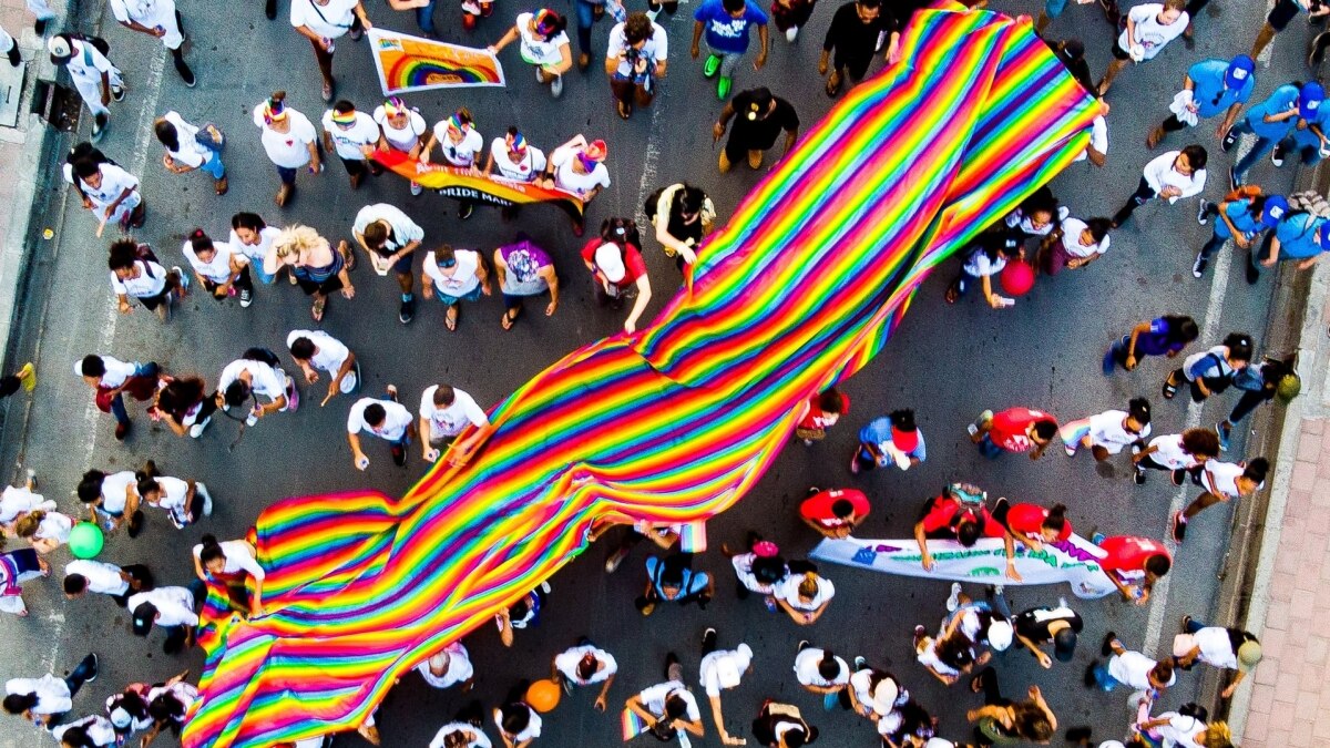 Desfile DEL ORGULLO con una gran bandera DEL ORGULLO
