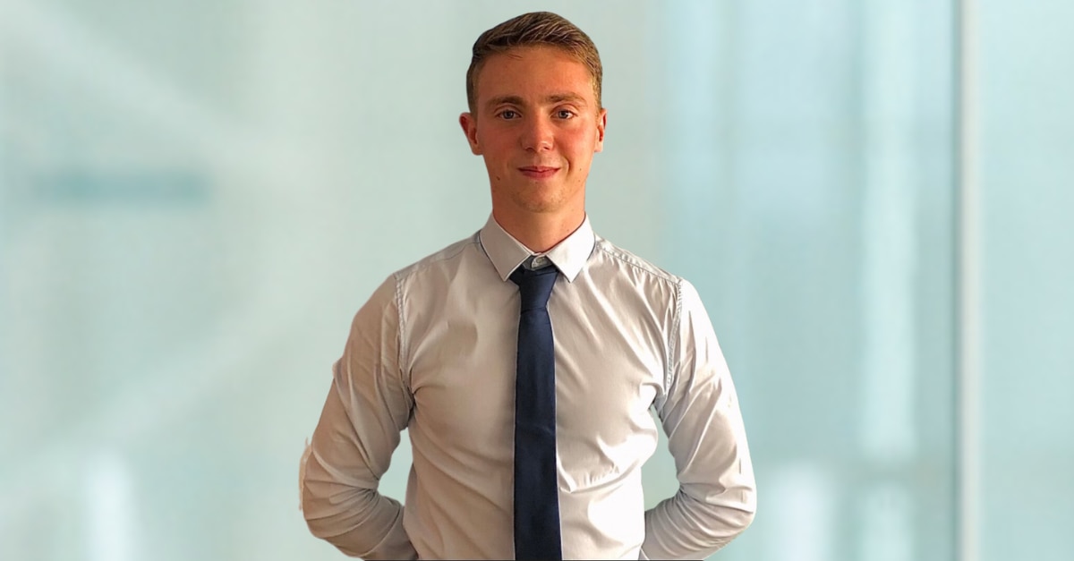 Foto de Fabio con camisa blanca y corbata negra sobre fondo azul claro