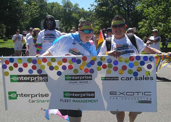 Amy y Ace pasean en un desfile con el banner de Enterprise