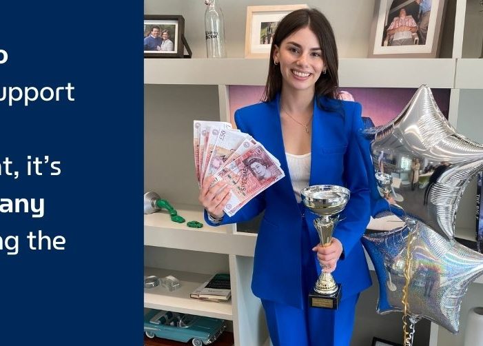 Sophie sosteniendo un trofeo, dinero y globos con una cotización