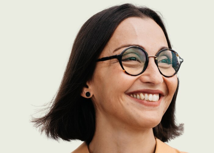 Mujer sonriendo con "Día Internacional de la Mujer Abrace Equity" escrito en el fondo