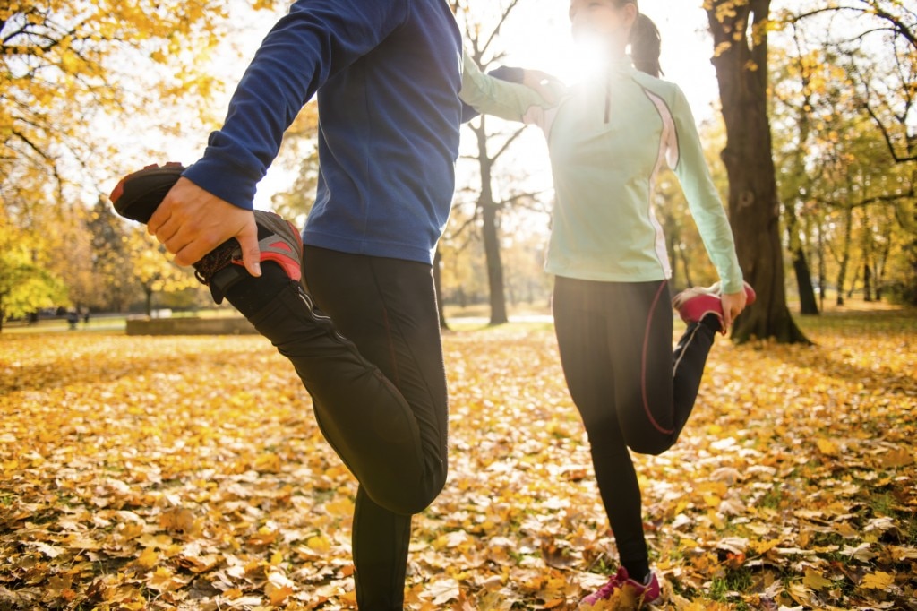 dos personas estirándose antes de correr