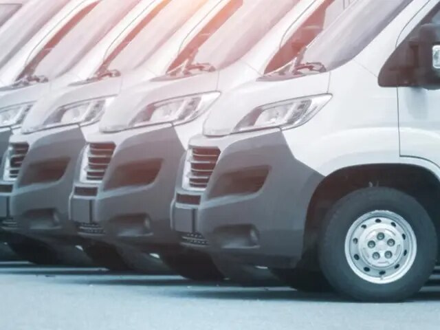 Larga fila de furgonetas blancas para pasajeros